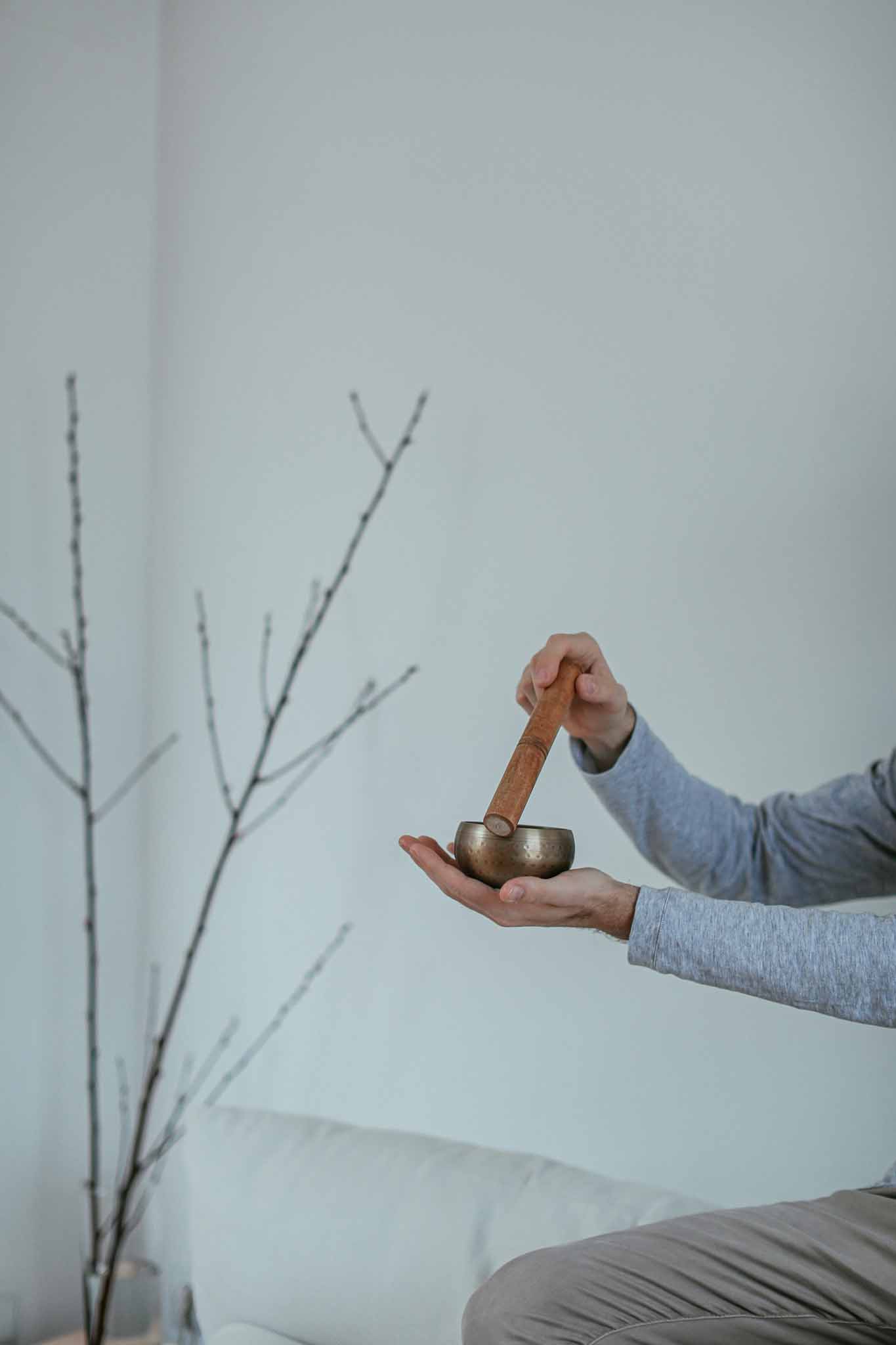 Close-up of a person using a Tibetan singing bowl for Qì regulation and emotional grounding, symbolizing sound-based boundary cultivation.